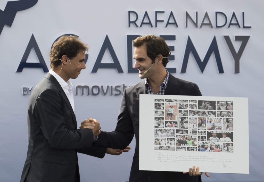 Roger Federer recibe el cuadro de regalo por parte de Nadal.