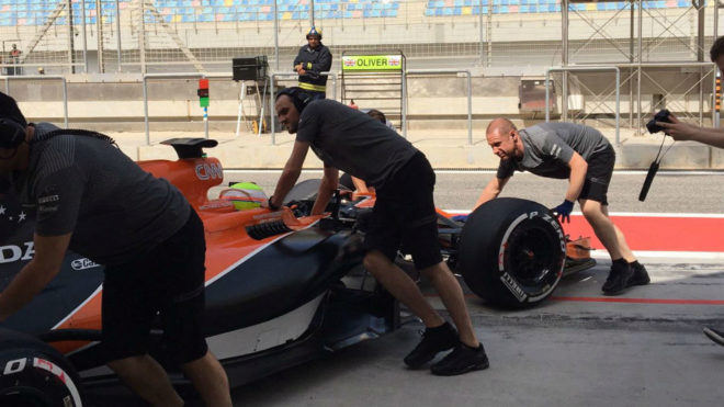 Los mecánicos de McLaren meten el coche de Oliver Turvey en el box...