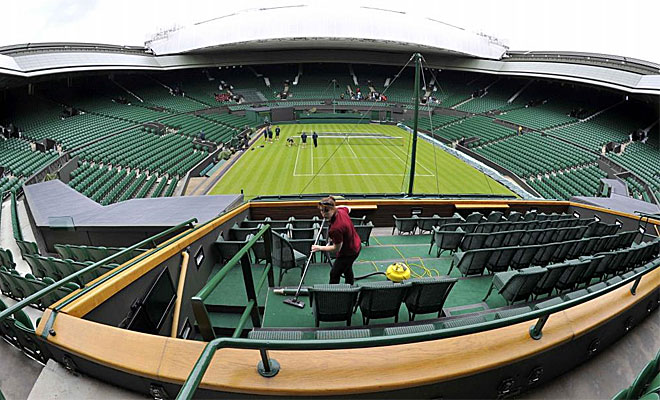 Los operarios que trabajan en el 'All England Tennis Club' apuran los �ltimos detalles para que todo est� a punto en la pista central antes del comienzo de todos los partidos.