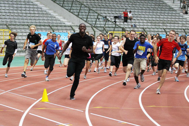 El campen olmpico, el jamaicano Usain Bolt, dando un sprint con una gran cantidad de voluntarios en el estadio Rey Balduino de Bruselas (Blgica), para presentar el 'Belgian IAAF Golden League Memorial Van Damme'.