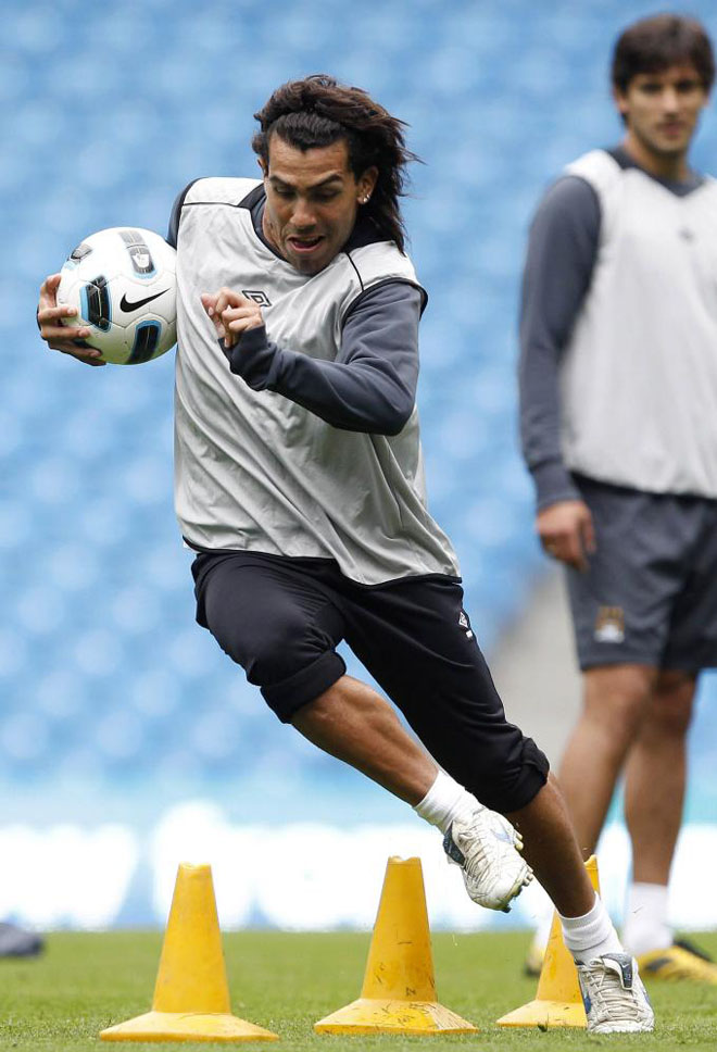 El delantero argentino del Manchester City Carlos Tvez, se ejercita corriendo con el baln en el inicio de la sesin de entrenamiento celebrada en el estadio de los Citizens.