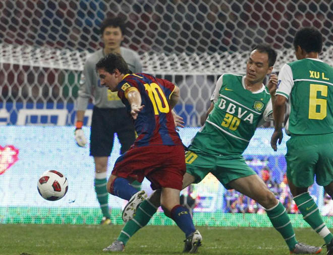 Lionel Messi intenta driblar a al defensa del Beijing Guoan Zhang Yonghai, en el partido que est disputando el Bara en tierras asiticas.