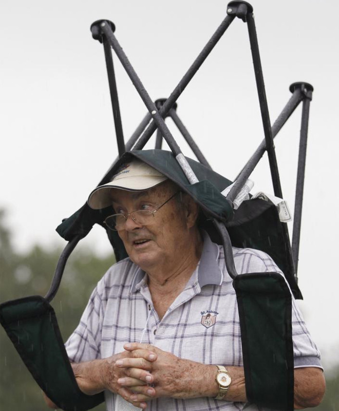 La PGA de golf no para de traernos imgenes sorprendentes. En esta foto, un espectador se refugia de la lluvia cubrindose con su propia silla