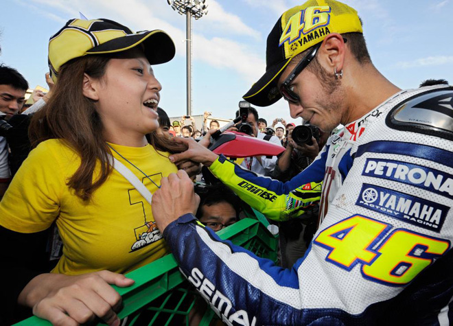 Valentino Rossi firmando un autgrafo a una aficionada durante la sesin de entrenameintos en Japn.