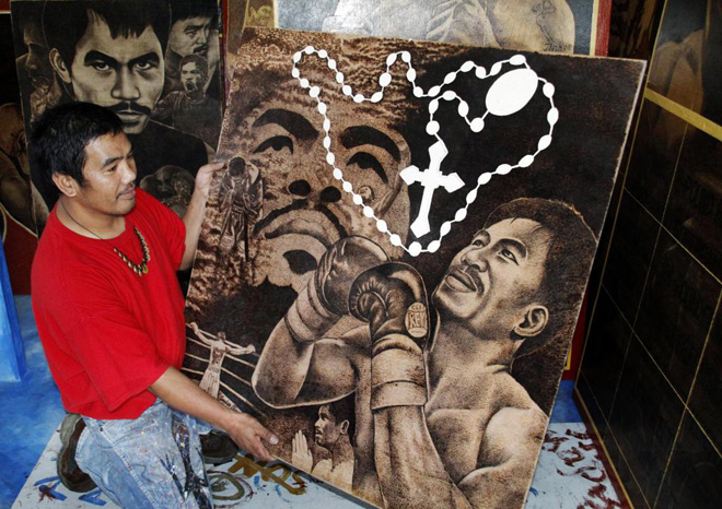 El artista Jordan Mangosan mostrando su obra inspirada en la figura del boxeador Manny Pacquiao.