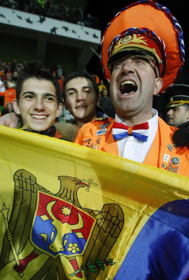 Un vistoso aficionado holands posa con seguidores moldavos durante el encuentro entre sus respectivas selecciones. La 'Oranje' venci 0-1 con un tanto de Huntelaar.