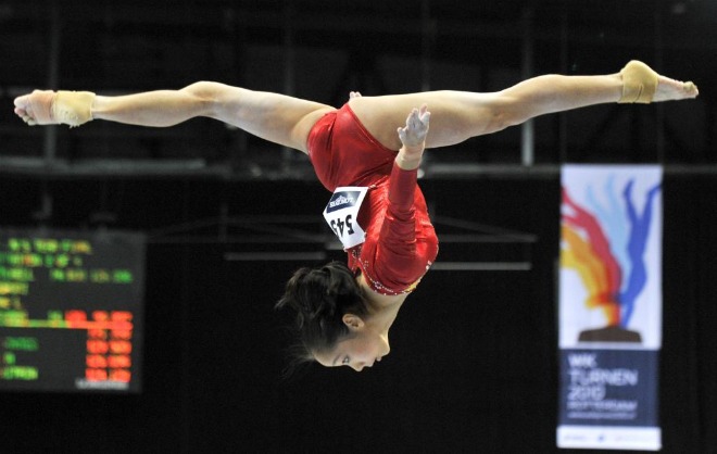 La china Linlin Deng realiza un salto en la disciplina de barra durante los Campeonatos del Mundo de Gimnasia artstica de Rotterdam.