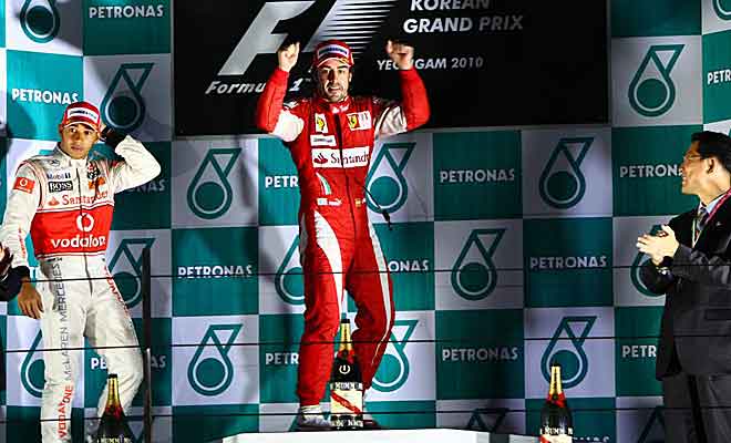 El piloto asturiano se muestra feliz tras la victoria en Corea y alza los brazos con Hamilton a su derecha