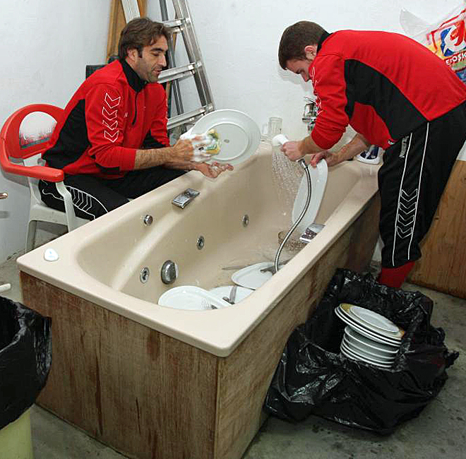 Jugadores del Algeciras lavando los platos en una baaera de los vestuarios tras su encierro por impagos.