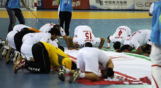 Los jugadores de Irn rezan en torno a una bandera de su pas tras vencer a Japn en una de las semifinales de balonmano de los Juegos Asiticos.