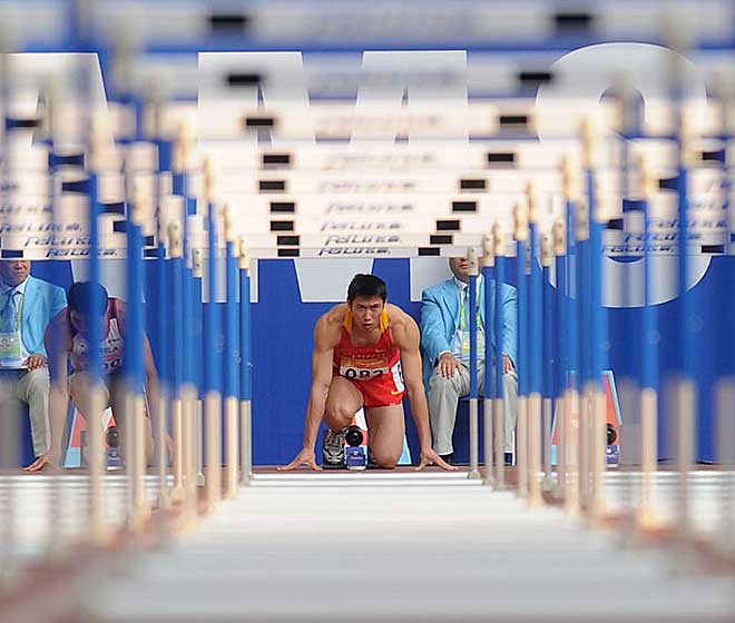El chino Yu Bin se prepara en la profundidad para afrontar la prueba de los 110 metros vallas de los Juegos Asiticos de Guangzhou