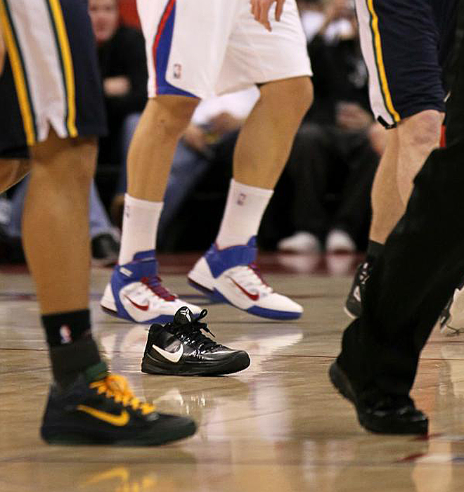 Varios jugadores de Los Clippers y los Jazz caminan al vestuario tras el término del segundo cuarto. Una zapatilla busca dueño.