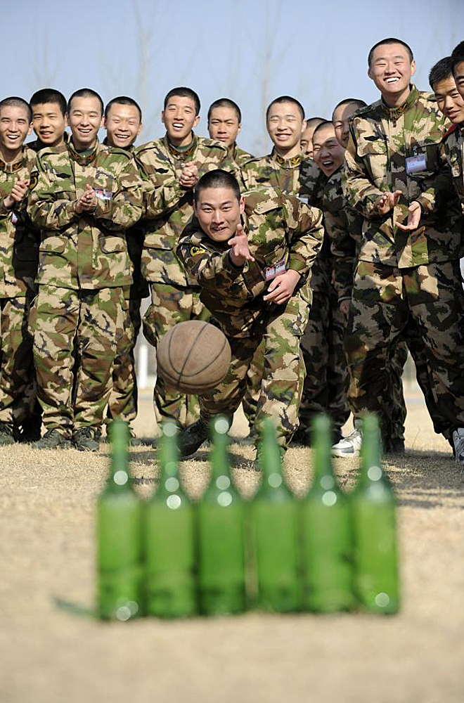 Varios militares juegan a una especie de bolos con botellas y un balón de baloncesto en la base de Huaibei, dentro de la provincia de Anhui, en la Repúpluica Popular China.