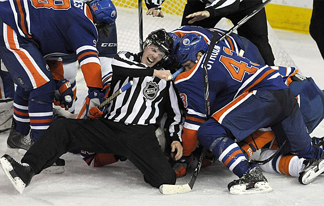 En el partido de la NHL entre los Edmonton Oilers y los New York Islanders el rbitro se meti en medio de una trifulca entre los jugadores para intentar separar y al final casi sale mal parado.
