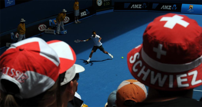 Dos seguidores suizos, pertrechados con gorros adornados con la bandera de su pas, observan atentos el duelo entre sus compatriotas Federer y Wawrinca.
