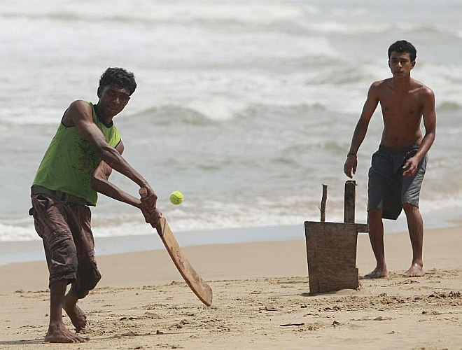 Los jovenes disfrutan jugando al cricket en la playa de la montaa Lavinia en Sri Lanka de una forma original y curiosa