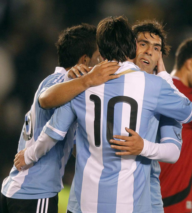 Carlos Tevez sonriente despus del gol marcado y por la felicitacin de sus compaeros Lionel Messi y Sergio Agero