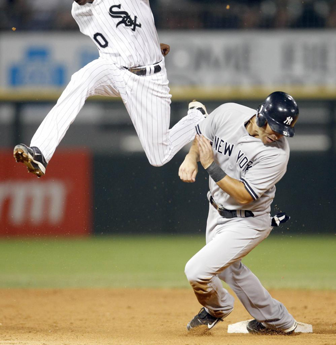 Alexei Ramrez (L) del White Sox de Chicago salta por encima de Eric Chvez, de los Yanquis de Nueva York para terminar la sptima entrada durante el partido de bisbol de la Liga Americana de bisbol en Chicago.