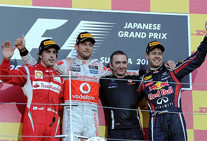 Alonso, Button y Vettel, junto a un mienbro del equipo Red Bull, se abrazan en el podio.