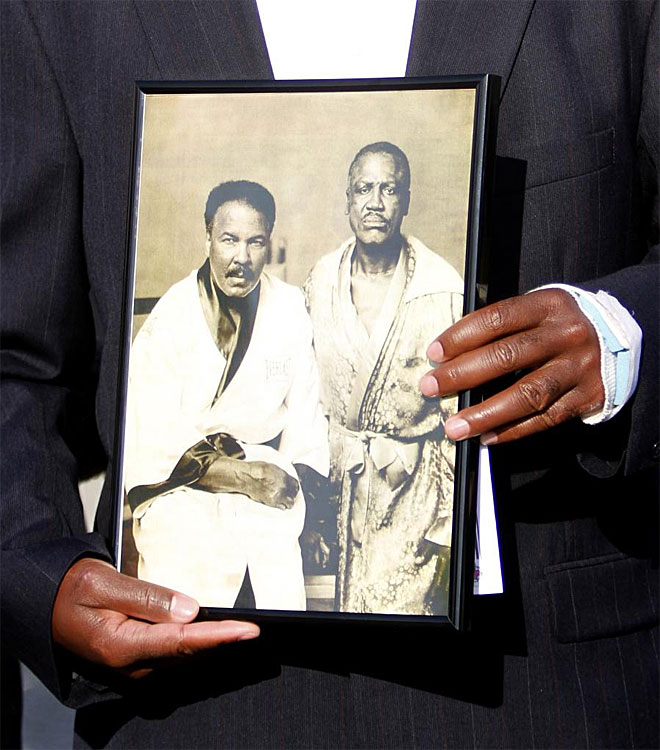 Uno de los asistentes al funeral muestra una foto en la que se ve a Frazier junto a Ali, rivales en el cuadriltero pero grandes amigos fuera de l.