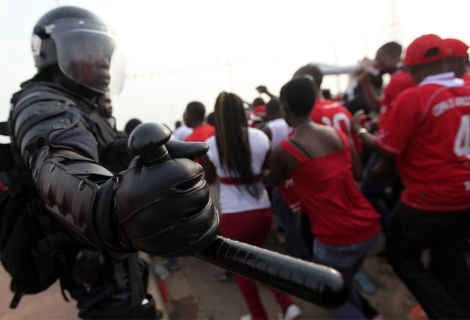Este polica mantiene una lnea de seguridad para que ningn aficionado de Guinea Ecuatorial se salga del camino.