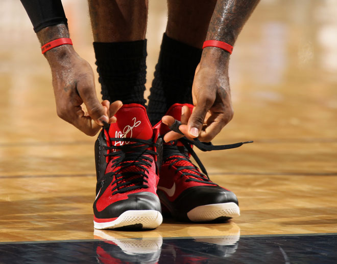 LeBron James anudndose las zapatillas durante el partido que sus Heat ganaron a los Nets.