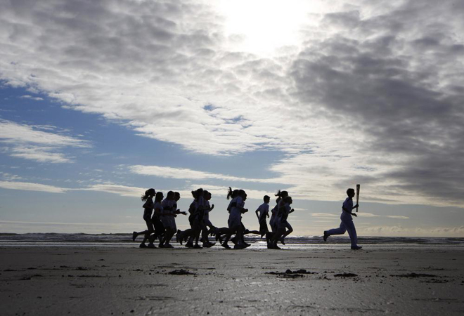 13/06/12: La antorcha olmpica recrea el paseo por la playa de West Sands, donde comenzaba la primera secuencia de la pelcula.