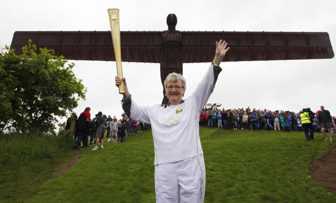 16/06/12: Iris Hutchinson porta la antorcha, frente a la estatua del ngel, situada al norteorte de Gateshead, noreste de Inglaterra,