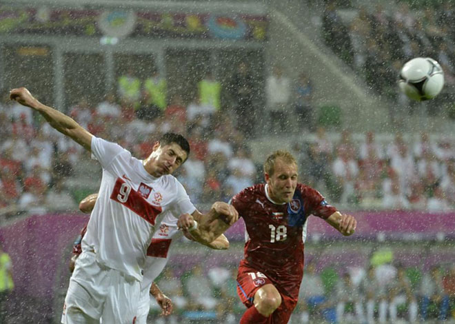 Lewandowski y Kolar pugnan por el esfrico de cabeza en medio de una lluvia intenssima que amain en los ltimos compases del primer periodo.