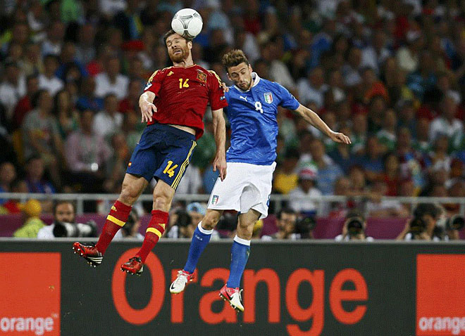 Spain's Xabi Alonso goes for a header with Italy's Claudio Marchisio (R) during their Euro 2012 final soccer match at the Olympic Stadium in Kiev , July 1, 2012.