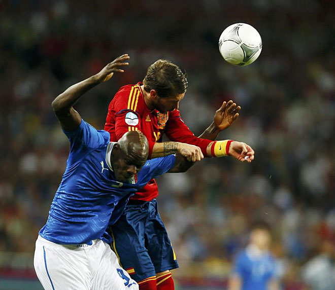 Italy's Mario Balotelli (L) heads the ball with Spain's Sergio Ramos during their Euro 2012 final soccer match at the Olympic stadium in Kiev.