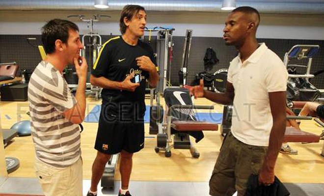 Abidal charl animadamente con Messi en el gimnasio del club