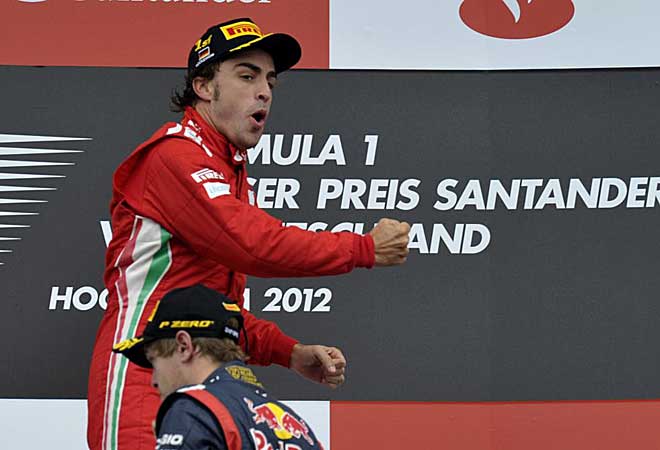 Alonso celebra la victoria en el podio con Vettel delante.
