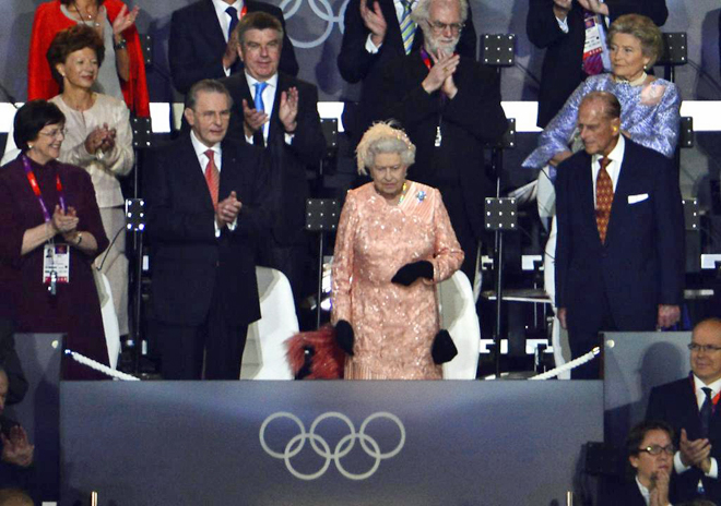 La Reina saluda en el palco junto a su esposo y el presidente del COI.