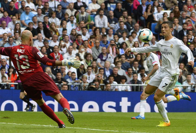 Cristiano Ronaldo prepares to kick a ball near Malaga's Argentinian goalkeeper Willy Caballero during the Spanish league football match Real Madrid vs Malaga.