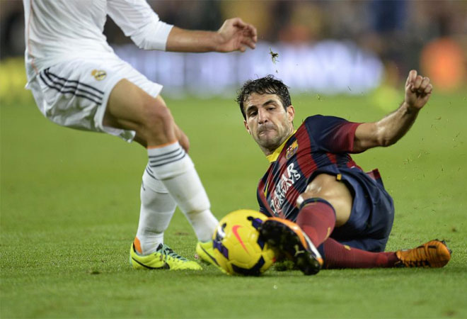Cesc Fabregas vies with a Real Madrid player during the Spanish league Clasico football match.