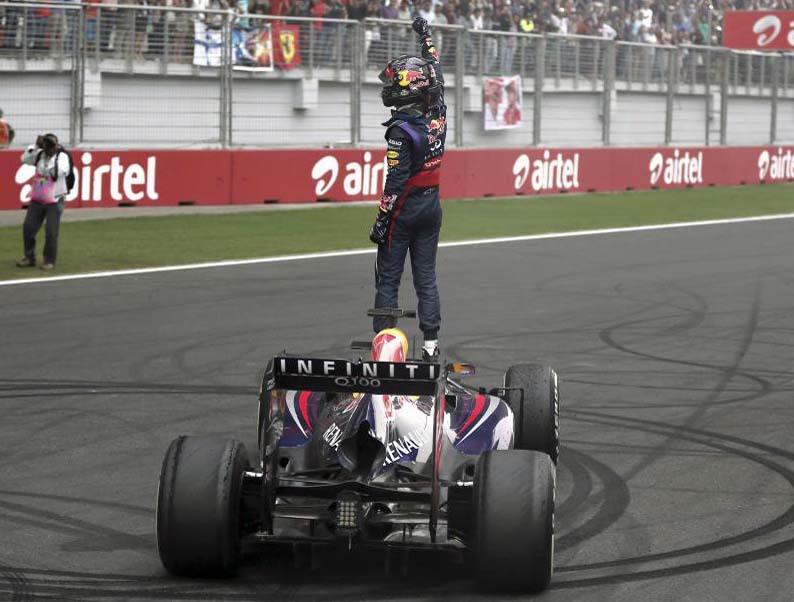 Vettel subido encima del coche mirando a los aficionados celebrando su cuarto ttulo.