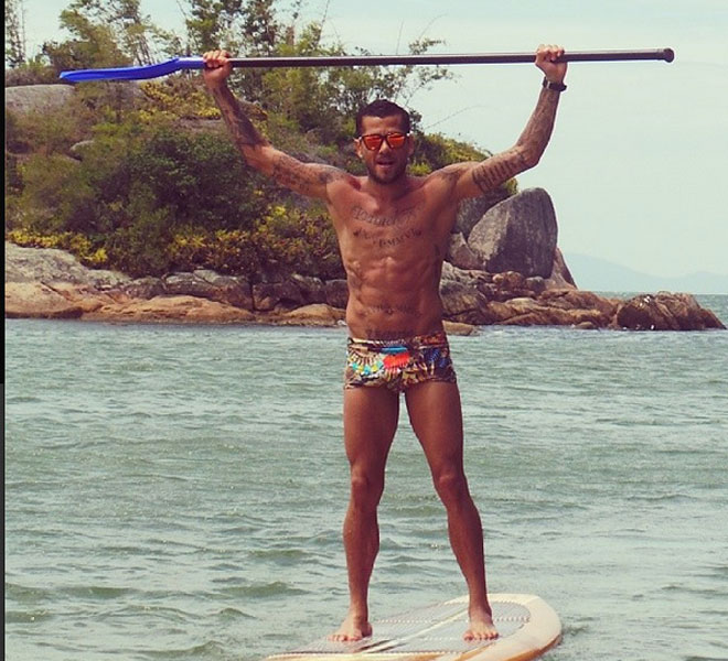 Dani Alves no tiene que volver hasta el da 2 de enero y apura sus vacaciones en Brasil haciendo pdel surf y mostrando su cuerpo atltico.