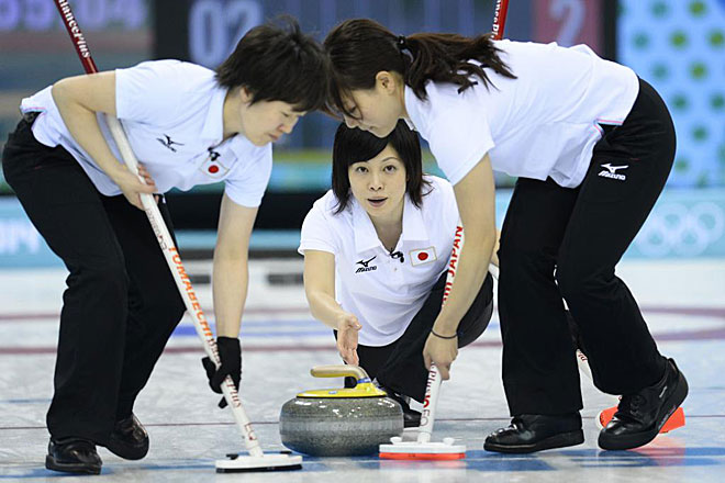 El equipo japons de curling, con Yumie Funayama como lanzadora, en la ronda 12, trabajando conjuntamente.