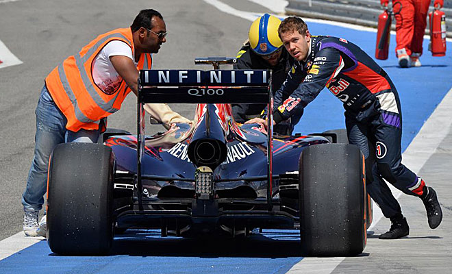 Vettel, empujando su RB10 a boxes despus de que se le parara por segunda vez en el da.