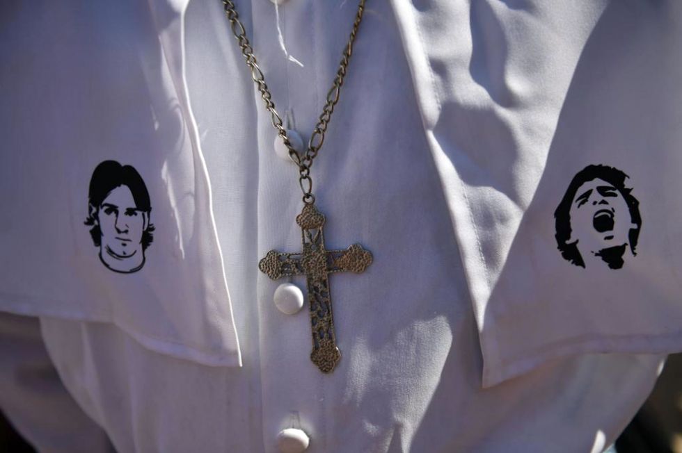 Un aficionado lució una túnica papal adornada con las imágenes de Messi y Maradona.