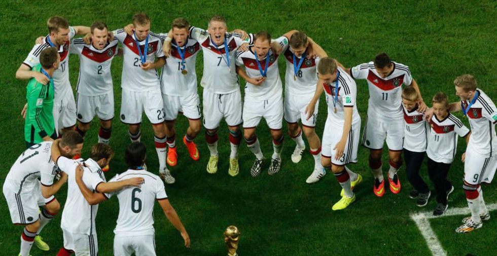 Los jugadores alemanes forman un corro alrededor de la Copa del Mundo.
