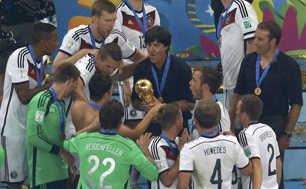 Löw agarra la copa ante la atenta mirada de sus jugadores.