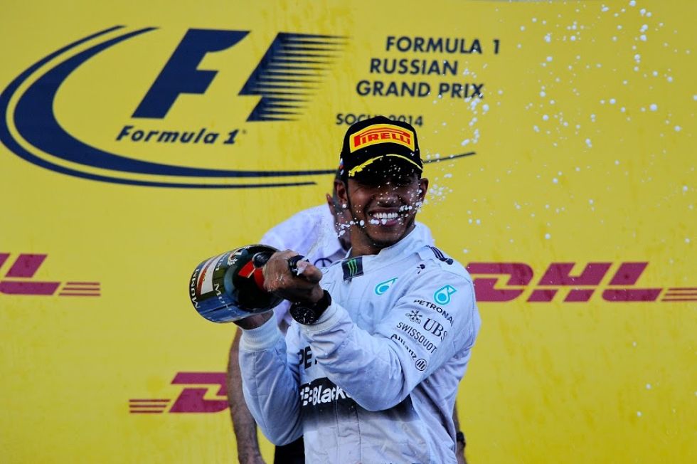 Hamilton sonre en el podio mientras desparrama champn tras su victoria que le acerca al ttulo.