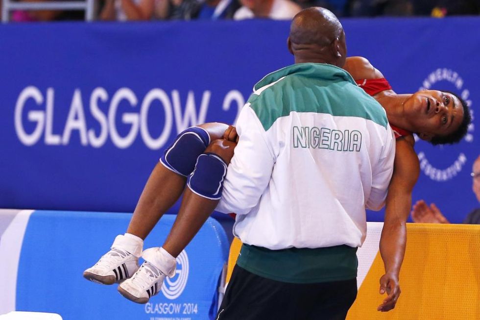 La luchadora Ifeoma Nwoye es llevada por su entrenador durante los juegos de la Commonwealth.