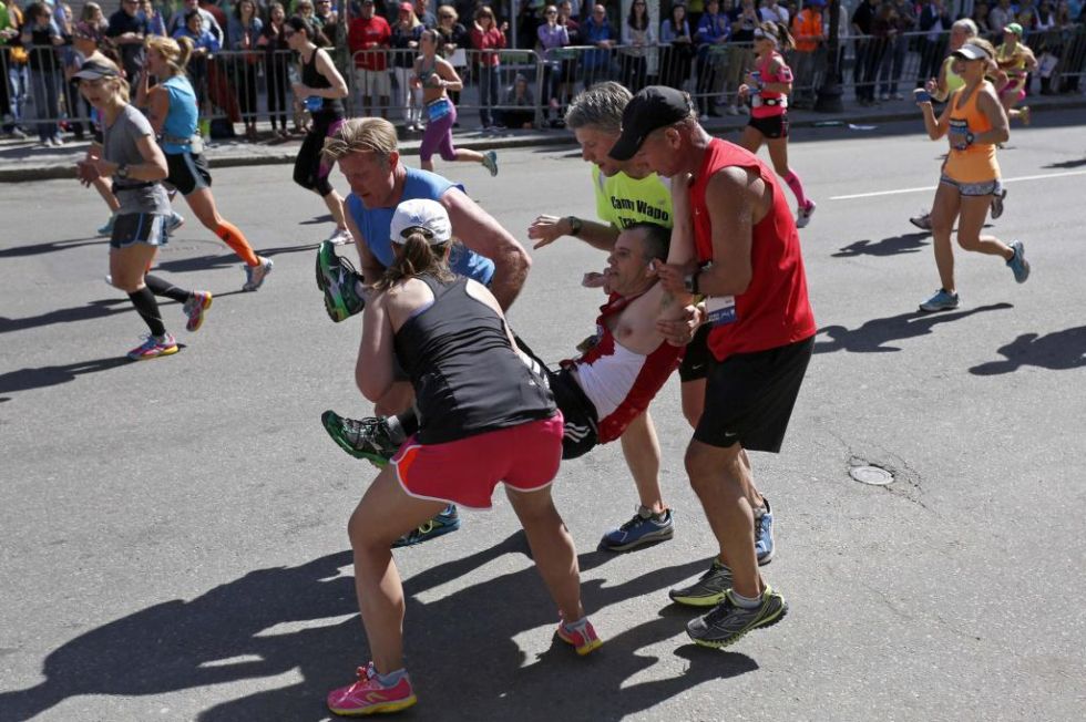 Cuatro corredores ayudan a otro a terminar el Maratn de Boston.
