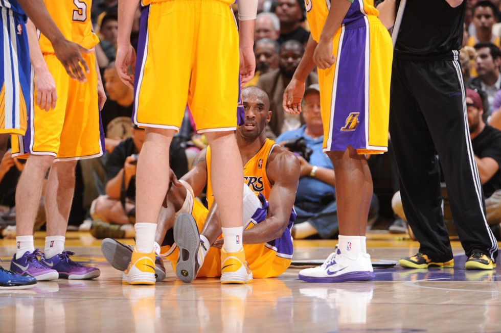 Kobe, rodeado de compaeros, cae lesionado del aquiles ante los Warriors.