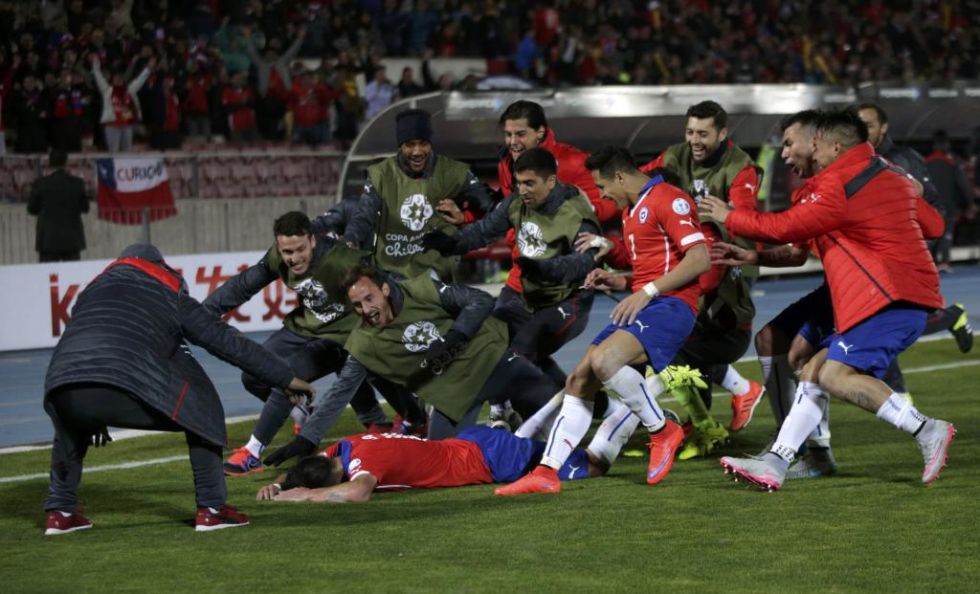 Los jugadores chilenos se abalanzan sobre Isla tras el gol de este.