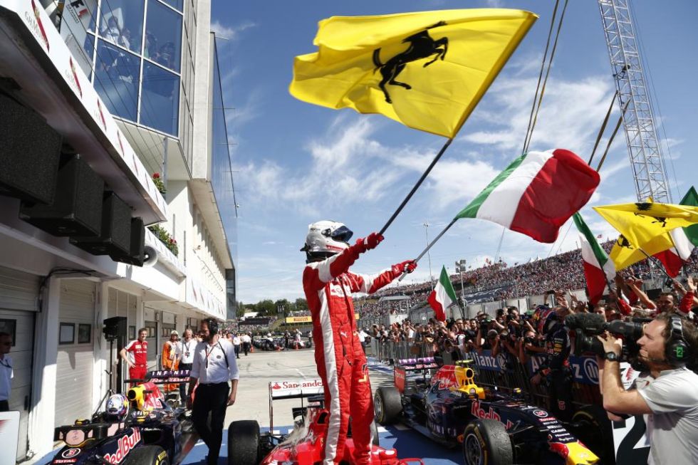 Vettel celebra la victoria con una bandera de Italia y otra de Ferrari