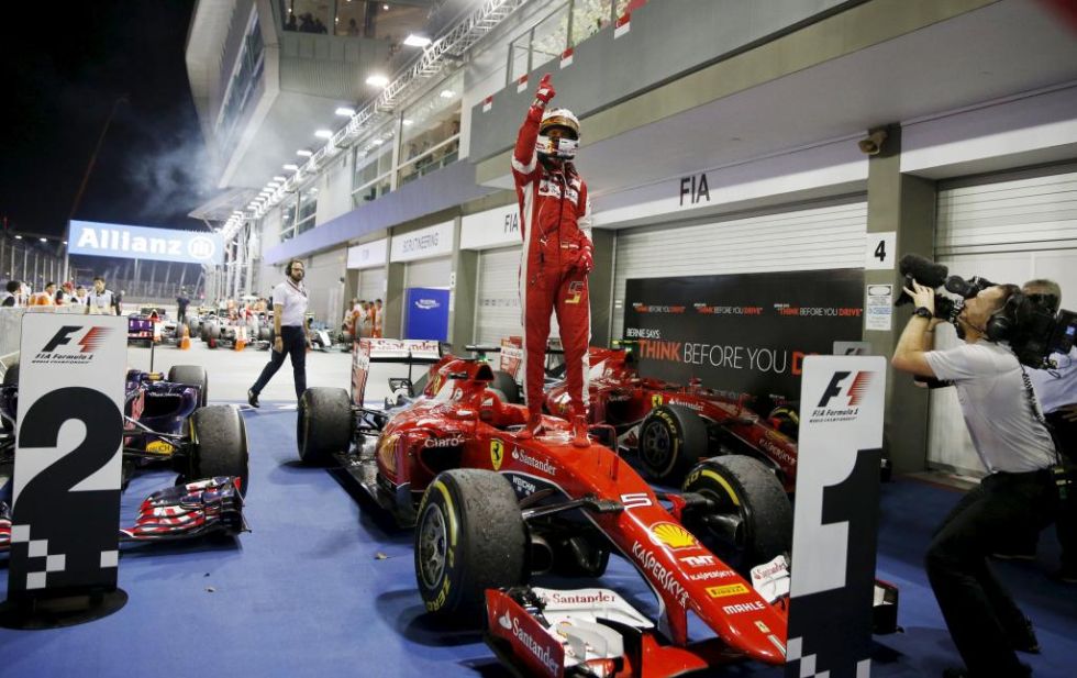 Sebastian Vettel celebra la victoria encima de su Ferrari.